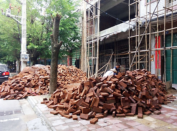 建设路建筑材料乱堆放，人行道变“拦路虎”